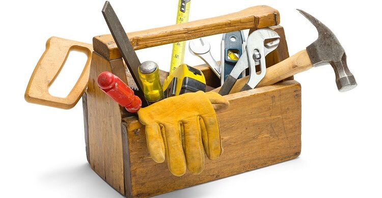 Wooden toolbox containing hammer, gloves, saw and ruler