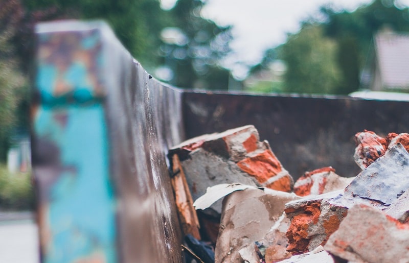 Broken bricks inside an old skip bin