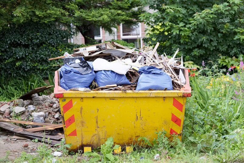 Overfilled skip bin in public space