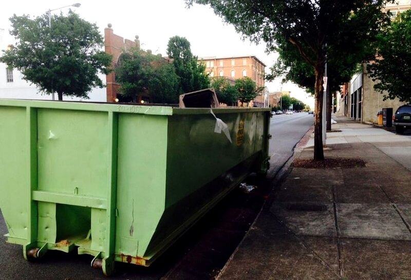 green skip bin placed on city street