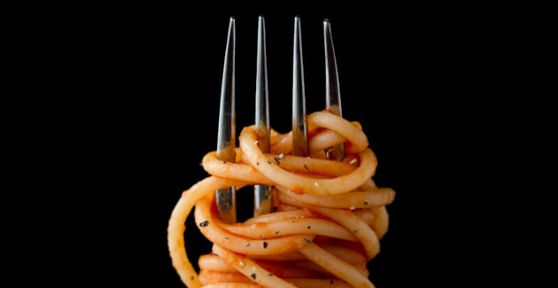fork with pasta on a black background